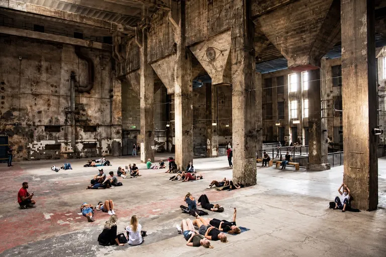 Interior de un club de música electrónica con sistema de sonido profesional, columnas y estructuras arquitectónicas visibles.